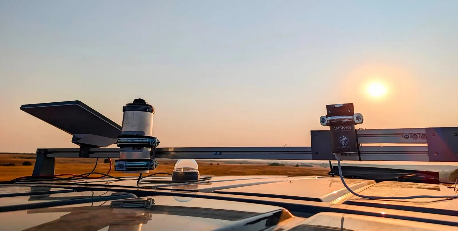 AMASC01 all-sky camera and AMSKY02 cloud sensor mounted on the car roof rack at sunset